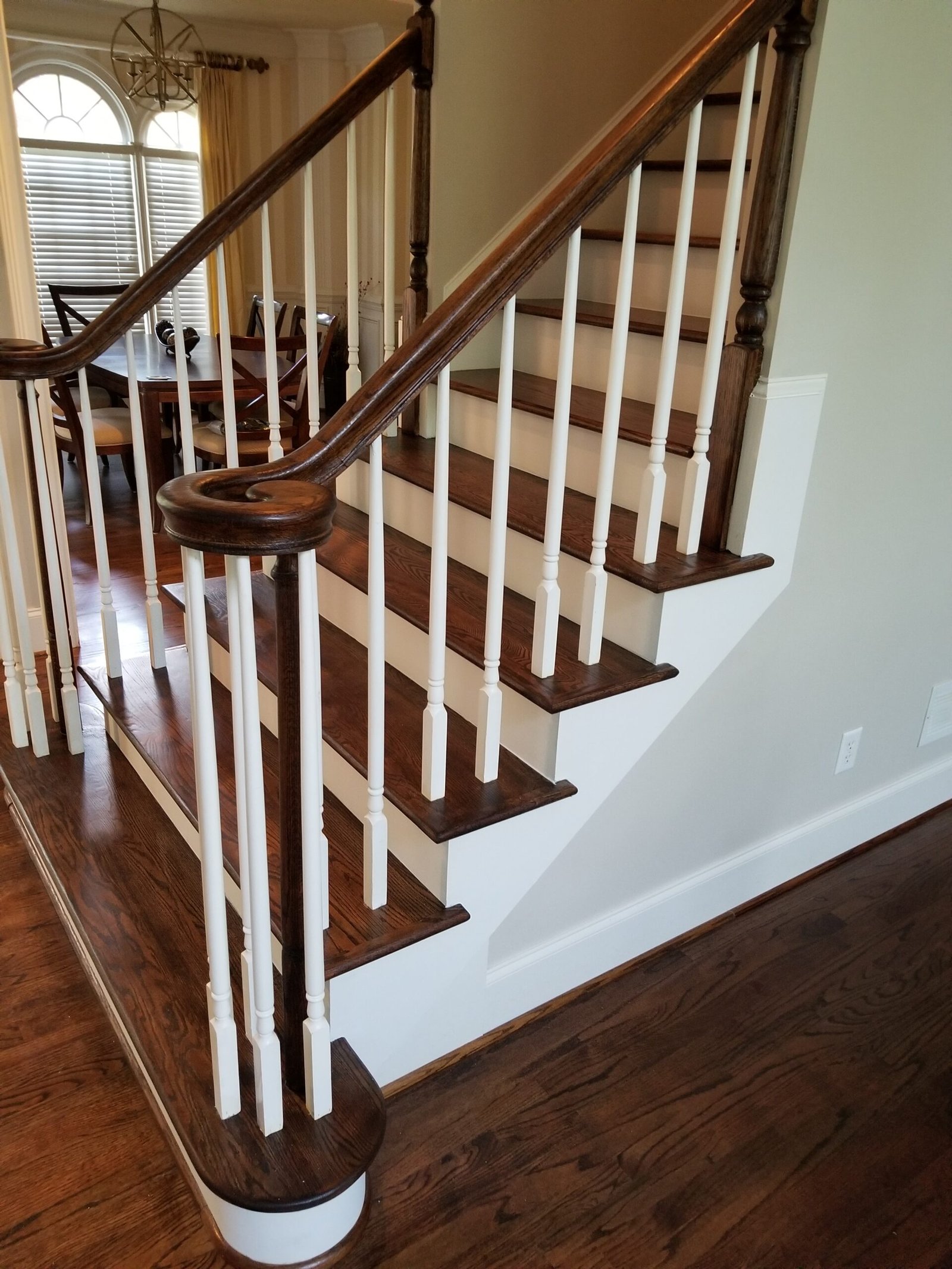 A stairway with a white railing and wood treads.