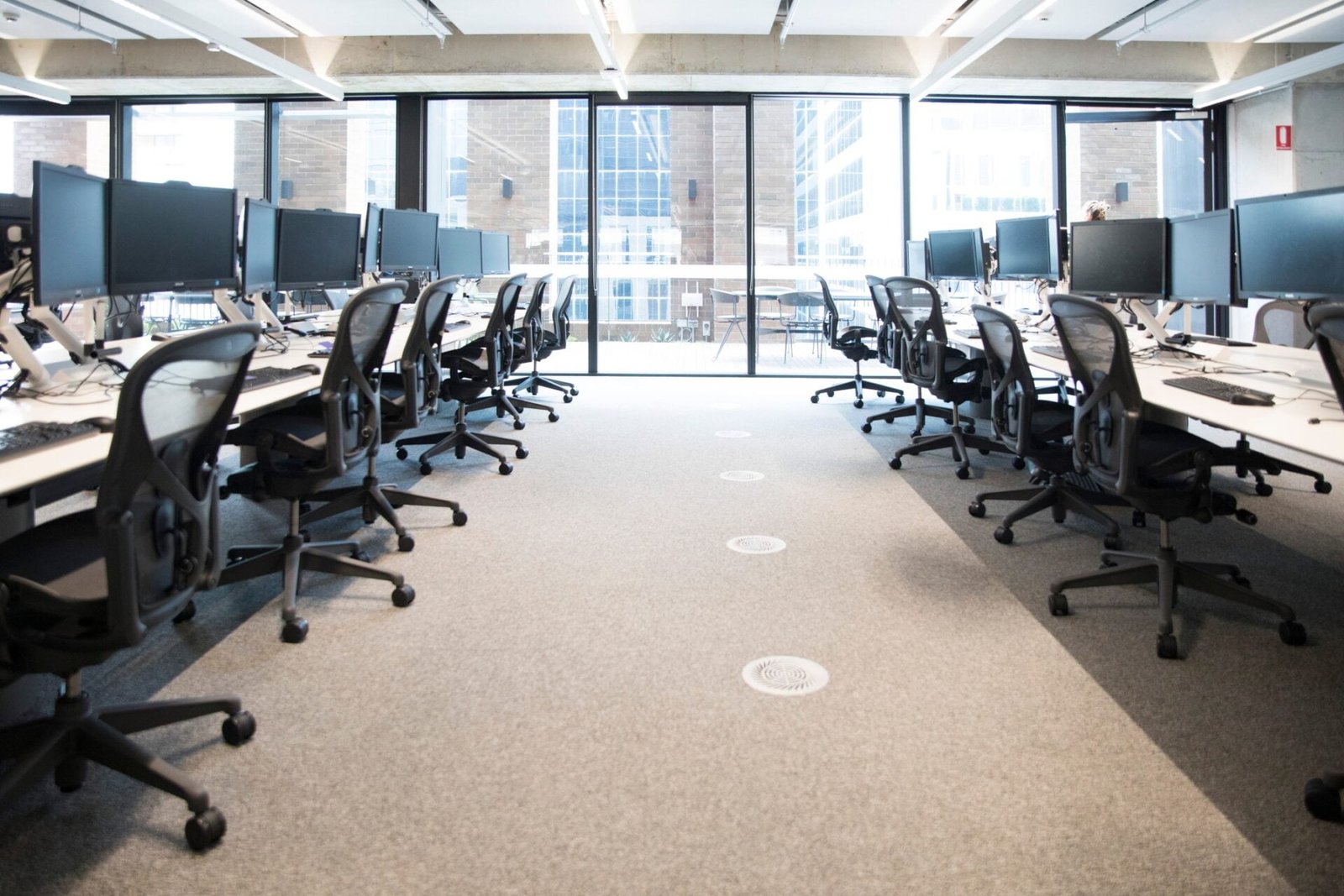 A large office with many desks and monitors.
