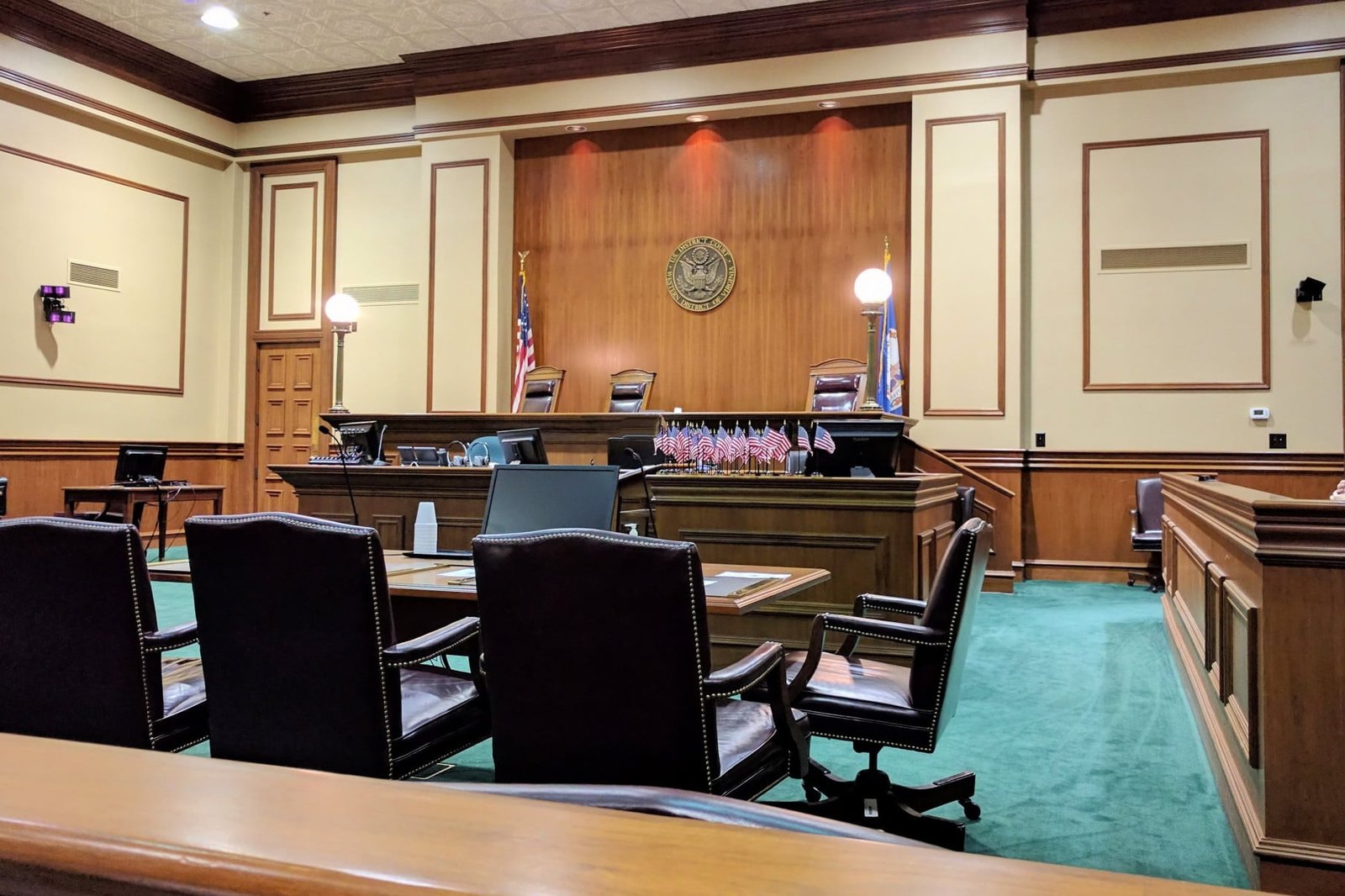 An empty courtroom with a desk and chairs.